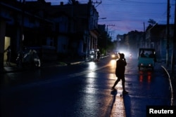 Una mujer cruza una calle durante un apagón, mientras La Habana sufre cortes de electricidad de 20 horas en medio de un bloqueo estadounidense que ha privado a la isla de combustible; La Habana, Cuba, 10 de junio de 2026. REUTERS/Norlys Perez
