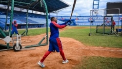 El jugador de béisbol cubano Yoelquis Guibert Steven (dcha.) participa en una sesión de entrenamiento en el Estadio Latinoamericano de La Habana el 29 de enero de 2026. YAMIL LAGE / AFP.