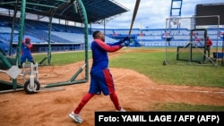 El jugador de béisbol cubano Yoelquis Guibert Steven (dcha.) participa en una sesión de entrenamiento en el Estadio Latinoamericano de La Habana el 29 de enero de 2026. YAMIL LAGE / AFP.