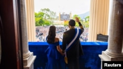 Nayib Bukele junto a su esposa Gabriela de Bukele desde el balcón del Palacio Nacional tras recibir la banda presidencial, durante la ceremonia de juramento de su segundo mandato en San Salvador, el 1 de junio de 2024. Presidencia de El Salvador /Folleto vía REUTERS