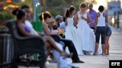 Una joven es ayudada por sus familiares a acomodar su vestido de quinceañera antes de posar para el fotógrafo en la Habana.