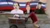 Un vendedor ambulante empuja su carrito junto a un mural con las imágenes de los fallecidos gobernantes Hugo Chávez (C), de Venezuela, y Fidel Castro, de Cuba, junto al presidente de Nicaragua, Daniel Ortega.