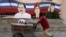 Un vendedor ambulante empuja su carrito junto a un mural con las imágenes de los fallecidos gobernantes Hugo Chávez (C), de Venezuela, y Fidel Castro, de Cuba, junto al presidente de Nicaragua, Daniel Ortega.