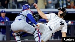 El receptor de los Dodgers de Los Ángeles, Will Smith (16), marca al bateador designado de los Yankees de Nueva York, Giancarlo Stanton (27), en el plato de home durante el tercer juego de la Serie Mundial de la MLB de 2024. (Brad Penner-Imagn Images v[ia Reuters)