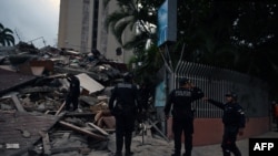 Agentes de la policía municipal permanecen junto a los restos de una estructura colapsada tras un terremoto en Caracas, el 24 de junio de 2026.