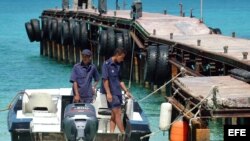 Dos soldados de las Tropas Guardafronteras (TGF) cubanas permanecen en una lancha en Cayo Confites, en la costa norte de la provincia de Camagüey. Archivo.