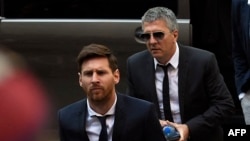 La estrella del fútbol del Barcelona Lionel Messi (izq.), su padre Jorge Horacio Messi (centro, atrás) llegan al juzgado de Barcelona el 2 de junio de 2016.