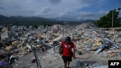 Un hombre camina entre los escombros de una estructura destruida en Catia La Mar, estado de La Guaira. (AFP)