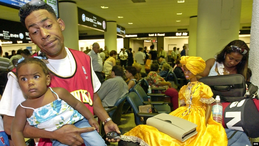 ARCHIVO. Una joven familia de emigrados cubanos esperan noticias sobre su vuelo hacia Cuba.