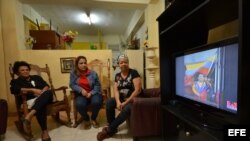 Una familia observa en la televisión la noticia de la muerte del presidente venezolano. Los problemas de salud de Chávez han generado en los cubanos preocupación por una nueva recaída económica en la isla.