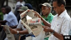 Varios hombres leen el diario oficial Granma en La Habana (Cuba). 
