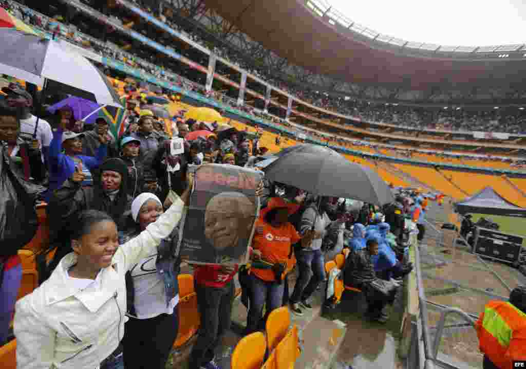 Una multitud de sudafricanos canta y baila mientras ocupa el estadio FNB de Soweto para asistir al servicio religioso oficial en memoria del expresidente Nelson Mandela.