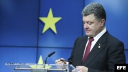 Petro Poroshenko, mira su bolígrafo mientras da una rueda de prensa en el ámbito de la segunda jornada de la cumbre de la Unión Europea en Bruselas (Bélgica).