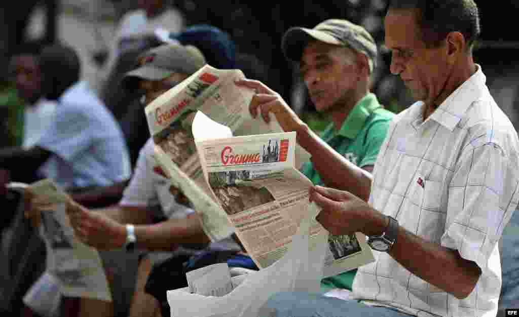 Varios hombres leen el diario oficial Granma en La Habana (Cuba). 