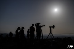 Aficionados a la astronomía se preparan para observar un eclipse solar parcial en la cima del Chasseral, sobre Nods, en el noroeste de Suiza, el 12 de agosto de 2026.