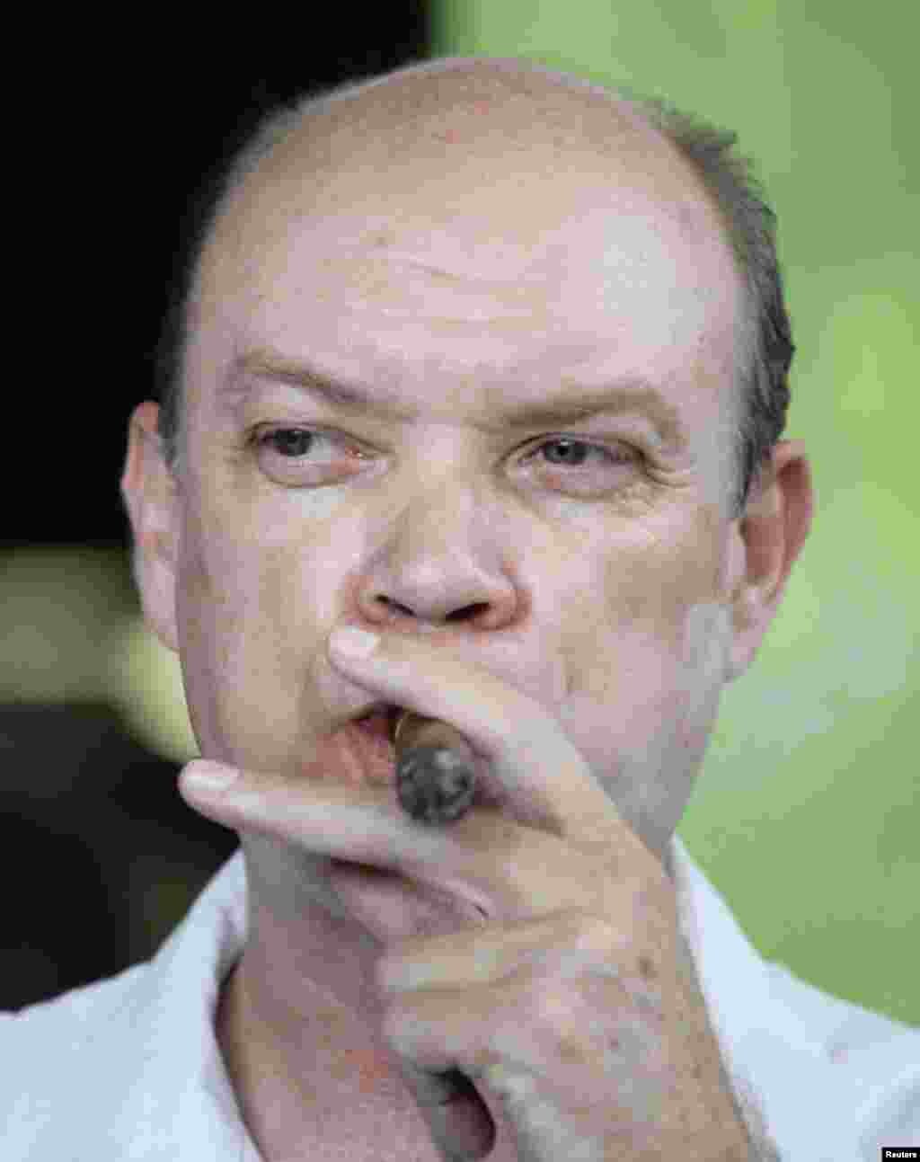 El Ministro de Comercio Exterior Rodrigo Malmierca fuma un Cohiba.