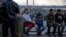 Migrantes esperan a la entrada del Puente Internacional Paso del Norte, en Ciudad Juárez. 
