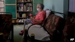 Norma Lidia Reyes espera para recibir una dosis de las gotas homeopáticas PrevengHo-Vir en su vivienda, en La Habana. (AP/Ismael Francisco)