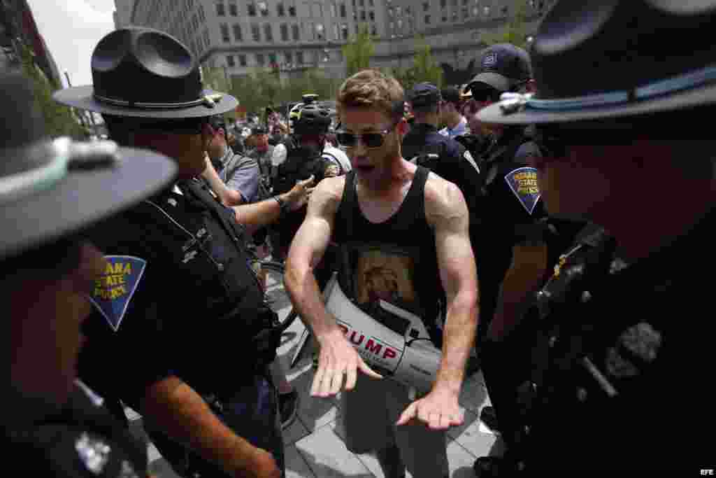 Policías separan a un hombre con un megáfono de un pequeño grupo de manifestantes anticapitalistas en Cleveland, Ohio, donde se lleva a cabo la Convención Nacional Republicana.