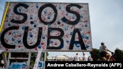 Un cartel de SOS Cuba en Washington, DC, el 18 de julio de 2021 (Photo by ANDREW CABALLERO-REYNOLDS/AFP).