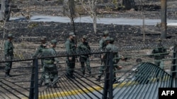 Miembros de la guardia nacional venezolana limpian las piedras y los escombros en la base militar de La Carlota en Caracas el 2 de mayo de 2019.