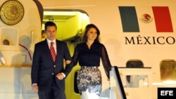 El presidente de México Enrique Peña Nieto (i) desciende junto a su esposa Angélica Rivera, en el aeropuerto internacional José Martí en La Habana (Cuba). 