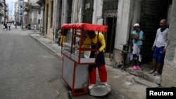 Un vendedor ambulante oferta comida en un carrito callejero en La Habana.