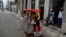 Un vendedor ambulante oferta comida en un carrito callejero en La Habana.