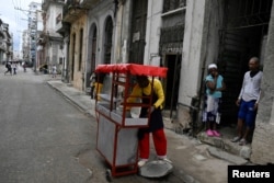 Un vendedor ambulante oferta comida en un carrito callejero en La Habana.
