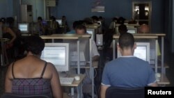 Cubanos haciendo uso del internet en un cibercafé en La Habana.