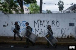 Miembros de la policía se enfrentan con un grupo de manifestantes durante una protesta de opositores al Gobierno venezolano.