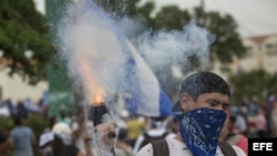 Un joven lanza mortero durante una multitudinaria marcha en apoyo a los estudiantes nicaragüenses.
