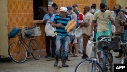 Cubanos hacen colas fuera de las tiendas para comprar pan en San José de las Lajas (Yamil Lage / AFP). 