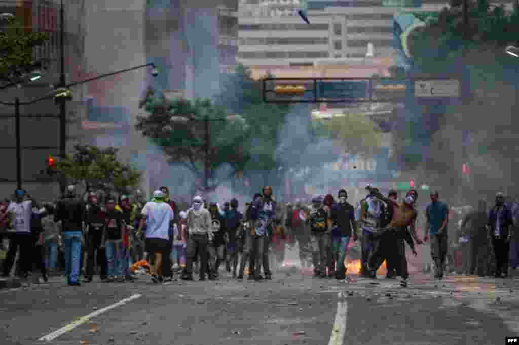 Manifestantes se enfrentan a miembros de la Guardia Nacional Bolivariana (GNB) hoy, jueves 12 de febrero de 2015, durante protestas en recuerdo de los fallecidos hace un año al término de una manifestación de la oposición, lo que dio inicio a un ola de pr