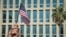 Un cubano sostiene una bandera de EEUU frente al edificio de la embajada de EEUU en La Habana. (Adalberto roque/AFP/Archivo)
