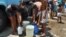 Cubanos se  abastecen de agua en pipas.