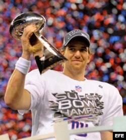 El mariscal de campo de los Giants de Nueva York Eli Manning levanta la copa Vince Lombardi después de derrotar a los Patriots de Nueva Inglaterra en el Super Bowl disputado hoy, domingo 5 de febrero de 2012, en el estadio Lucas Oil de Indiana (EEUU). Los