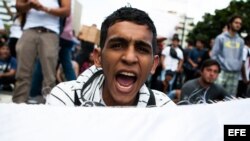 Un estudiante opositor al Gobierno venezolano durante una protesta estudiantil en la Plaza Altamira de Caracas el jueves 13 de febrero de 2014