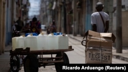 Una imagen cotidiana en La Habana: triciclo para cargar tanques de agua  