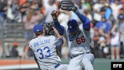 Yasiel Puig (d) y Scott Van Slyke (i) de Dodgers celebran tras vencer a Gigantes durante un juego de la MLB en el AT&T Park de San Francisco.