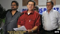El integrante de las Fuerzas Armadas Revolucionarias de Colombia (FARC) Jorge Torres Victoria (c), alias "Pablo Catatumbo" (i), lee un comunicado en el Centro de Convenciones de La Habana (Cuba). 