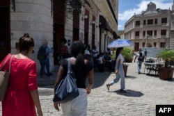 Se observa a trabajadores en una calle tras evacuar sus oficinas debido al temblor
