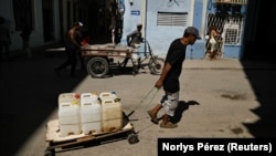 Un cubano traslada tanques de agua en una carretilla en La Habana. Foto: REUTERS/Norlys Pérez