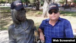 El escritor Ángel Santiesteban junto a John Lenon, ambos con gorra de Plantados