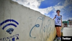 La bloguera disidente cubana Lia Villares junto a un grafiti con el nombre de El Sexto en una calle de La Habana.