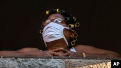 Una mujer mira por su ventana durante la pandemia del coronavirus en Cuba. AP Photo / Ramon Espinosa