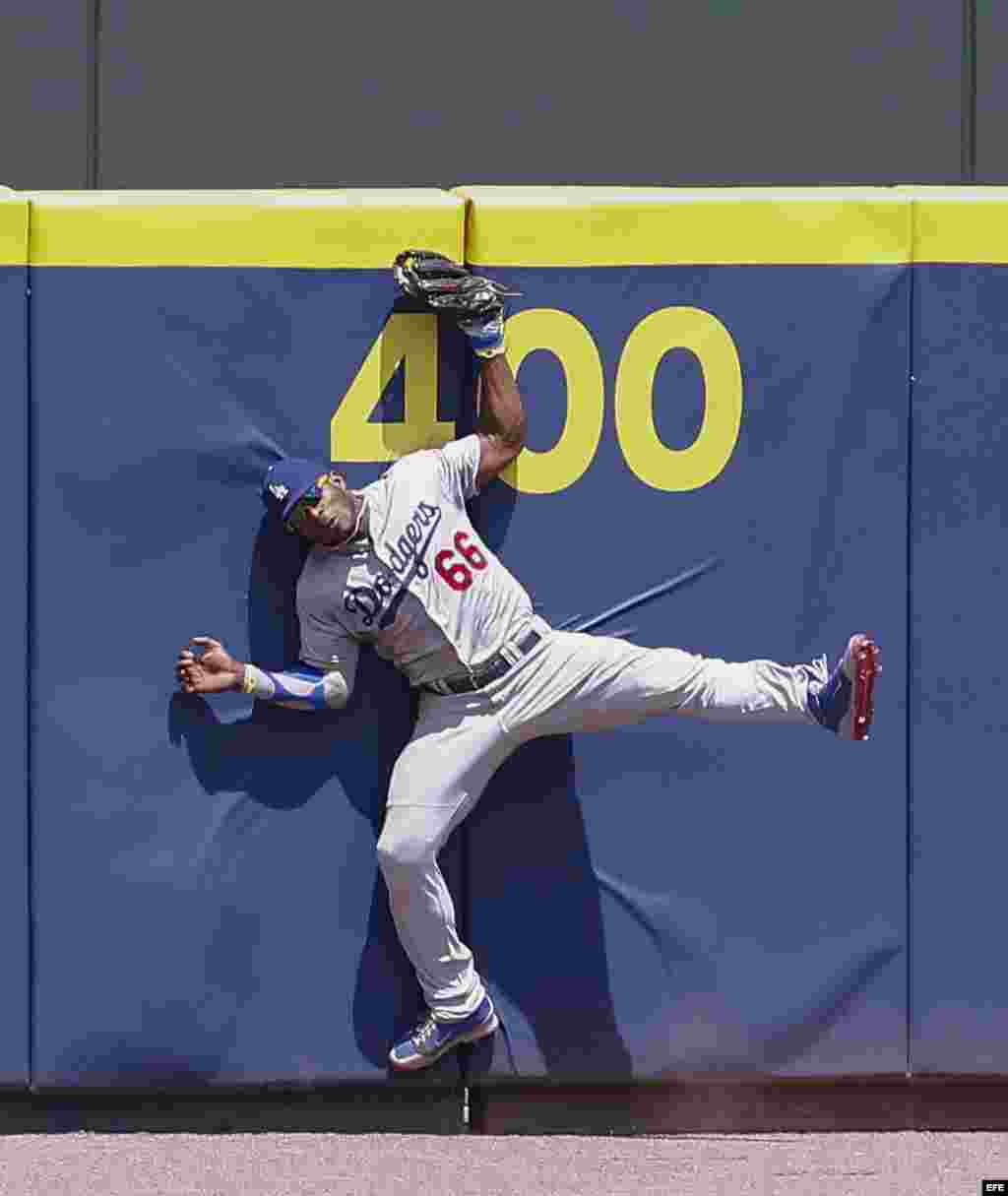  Yasiel Puig, captura una pelota en el aire, lanzada contra el muro por el primer base de los Bravos de Atlanta, Freddie Freeman.