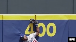  Yasiel Puig, captura una pelota en el aire, lanzada contra el muro por el primer base de los Bravos de Atlanta, Freddie Freeman.