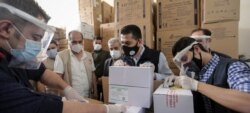 Abren cajas con la primera entrega de vacunas de COVAX contra el COVID-19 en Siria. Foto: UNICEF/COVAX.