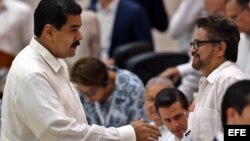 El presidente de Venezuela, Nicolás Maduro (i) saluda a Luciano Marín Arango, alias "Iván Márquez" (d), durante la ceremonia en La Habana (Cuba) el 23 de junio de 2016